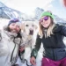 Photographie qui représente un couple avec leur chien à la montagne en période de neige.