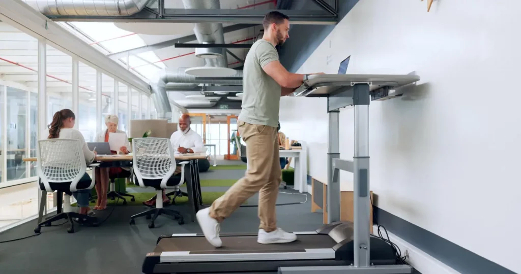 Bureau debout avec tapis de marche pour limiter la sédentarité au travail.